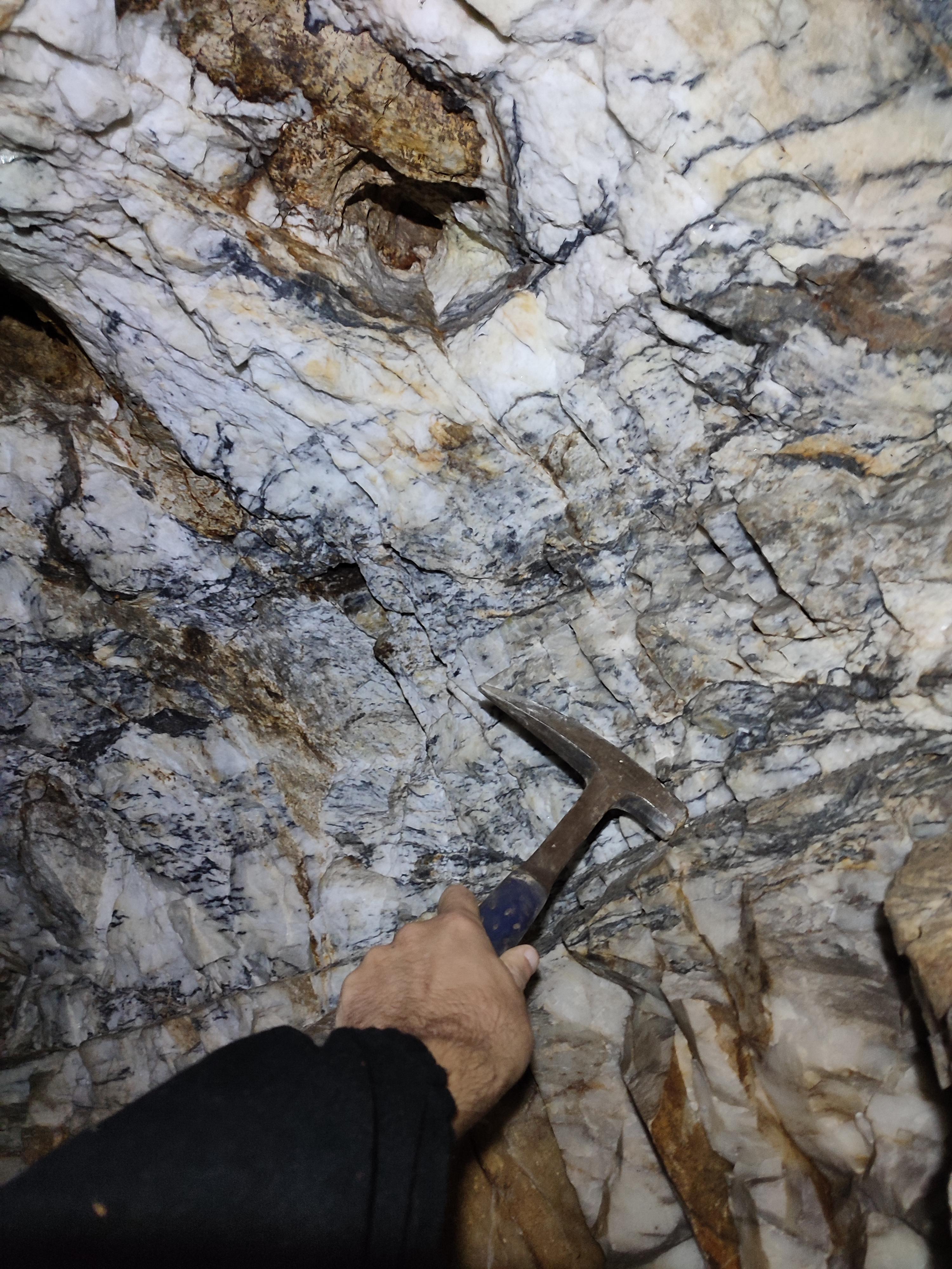 Barite vein with galena and sphalerite mineralisation at the Golden Hills project, shown with a rock hammer for scale